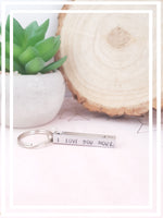 The 3D hand-stamped keyring features four sides with the heartfelt message, "I love you more, The end. I win." It is embellished with a stamped heart, where we can personalise it with an initial before the heart upon request.